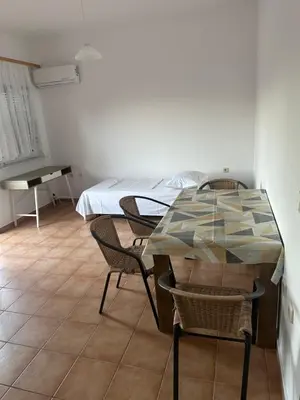 a room with a table and chairs and a bed at Κakle Kolympia Apartments in Kolimbia