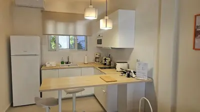 a kitchen with white cabinets and a wooden counter top at OASIS Central 007 in Rhodes Town