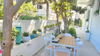 a patio with a table and chairs and potted plants at OASIS Central 007 in Rhodes Town