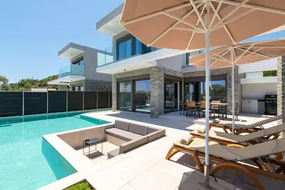 an external view of a house with a swimming pool at Rodos Stars Stellar Villas in Rhodes Town