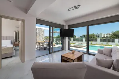 a living room with a couch and a tv at Rodos Stars Stellar Villas in Rhodes Town
