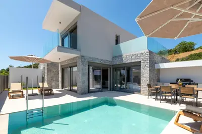 a villa with a swimming pool and a dining area at Rodos Stars Stellar Villas in Rhodes Town