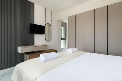 a bedroom with a white bed and a television at Rodos Stars Stellar Villas in Rhodes Town