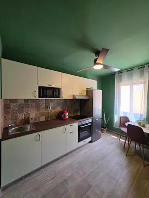 a kitchen with white cabinets and a table in a room at Canvas at Koskinou in Koskinou