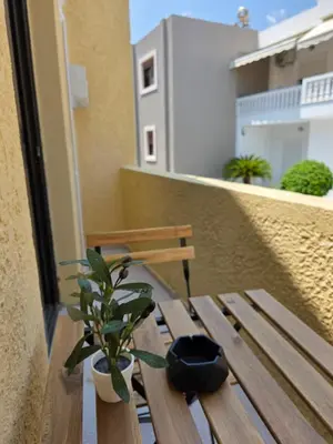 a wooden bench with a potted plant on a balcony at Canvas at Koskinou in Koskinou