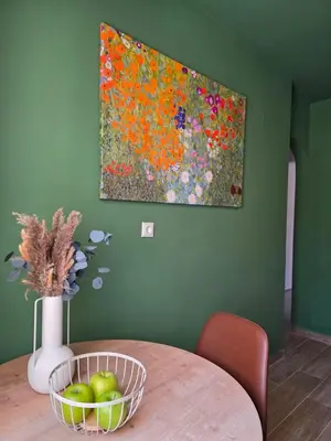 a painting of flowers on a green wall with a table at Canvas at Koskinou in Koskinou