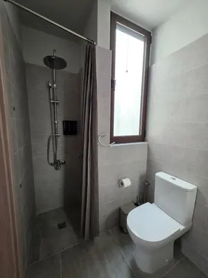 a bathroom with a toilet and a shower with a window at Canvas at Koskinou in Koskinou