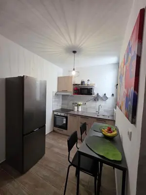 a small kitchen with a table and a refrigerator at Canvas at Koskinou 2 in Koskinou