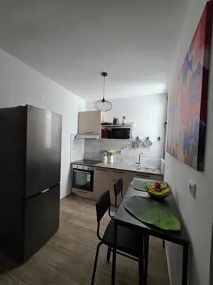 a small kitchen with a table and a refrigerator at Canvas at Koskinou 2 in Koskinou