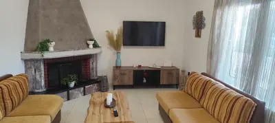 a living room with a fireplace and a tv at Ioanna's Home in Émbonas