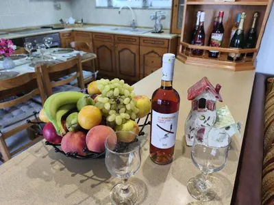 a bottle of wine and a bowl of fruit on a counter at Ioanna's Home in Émbonas