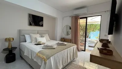 a white bedroom with a bed and a sliding glass door at Val & Rin Luxury Apartment in Rhodes Town