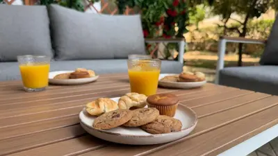 a table with a plate of cookies and two glasses of orange juice at Val & Rin Luxury Apartment in Rhodes Town