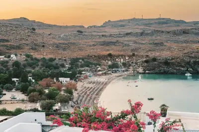 a view of a beach with pink flowers at Lindos Zen luxury villa in Líndos