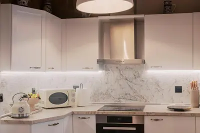 a kitchen with white cabinets and a microwave at Lindos Zen luxury villa in Líndos