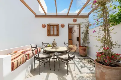 a room with a table and chairs on a balcony at Villa Vasoula Lindos, Jasmine and Gardenia Suite in Líndos