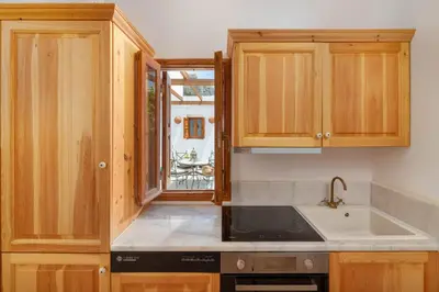 a kitchen with wooden cabinets and a sink at Villa Vasoula Lindos, Jasmine and Gardenia Suite in Líndos