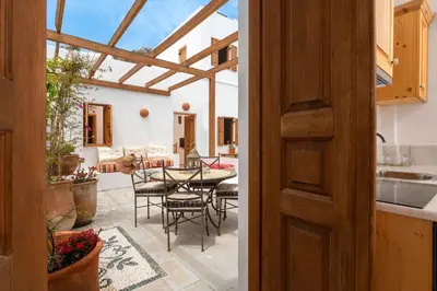 a door leading to a patio with a table and chairs at Villa Vasoula Lindos, Jasmine and Gardenia Suite in Líndos