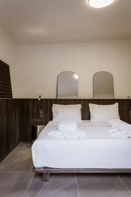 a bedroom with a bed with white sheets and pillows at HUGme Suite in Kalithies