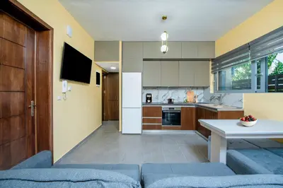 a kitchen and living room with a blue couch at Magical House in Ialyssos