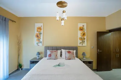 a bedroom with a large bed with flowers on the wall at Magical House in Ialyssos