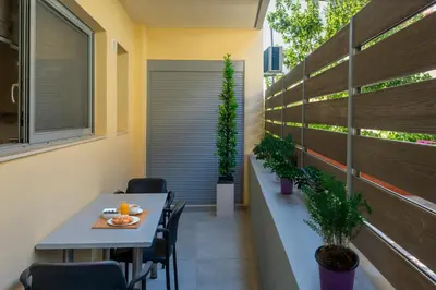 a dining area with a table and chairs and plants at Magical House in Ialyssos