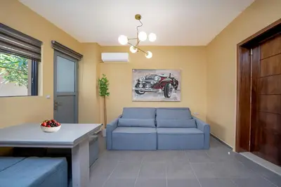 a living room with a blue couch and a table at Magical House in Ialyssos