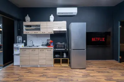 a kitchen with a stainless steel refrigerator in a room at House of Paralympic Athlete Mike Seitis in Rhodes Town