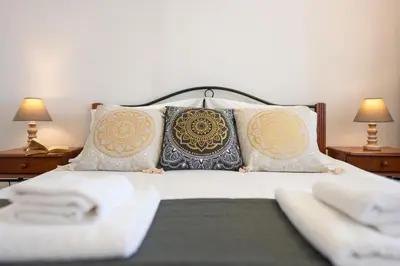a bedroom with a bed with pillows and two lamps at Fiore D'oriente Apartments in Rhodes Town