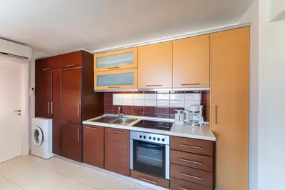 a kitchen with wooden cabinets and a sink at Fiore D'oriente Apartments in Rhodes Town