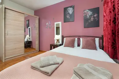 a bedroom with a large bed with pink walls at Casa Baboulas Old Town in Rhodes Town