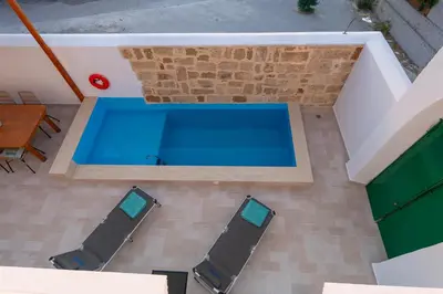 an overhead view of a swimming pool with chairs and a table at Villa Emerald in Koskinou