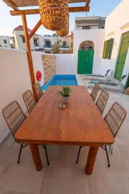 a wooden table and chairs on a patio at Villa Emerald in Koskinou
