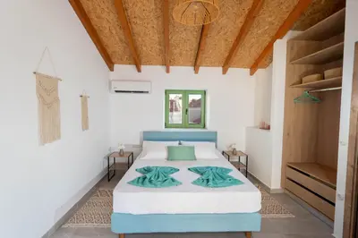 a bedroom with a bed and a wooden ceiling at Villa Emerald in Koskinou