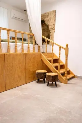 a room with a staircase and a table and stool at Villa Emerald in Koskinou