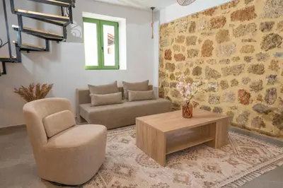 a living room with a couch and a chair and a table at Villa Emerald in Koskinou