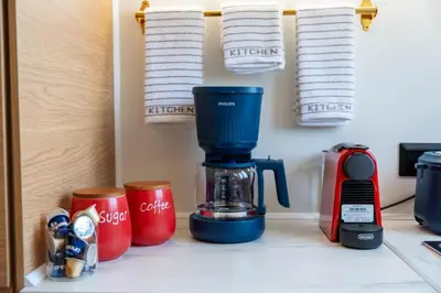 a coffee maker and cups on a kitchen counter at Irem's sunrise suite! in Rhodes Town