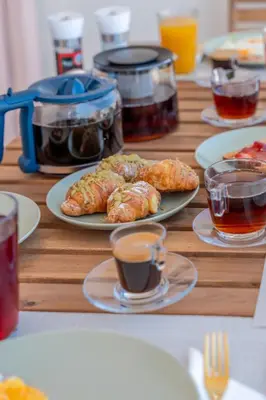 a table with plates of food and cups of coffee at Irem's sunrise suite! in Rhodes Town