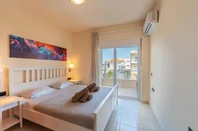 a bedroom with a bed and a balcony at Irem's sunrise suite! in Rhodes Town