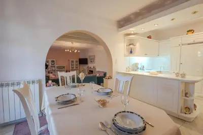 a kitchen and dining room with a white table and chairs at Makiaris Villa in Archangelos