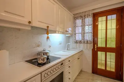 a white kitchen with a stove and a sink at Makiaris Villa in Archangelos