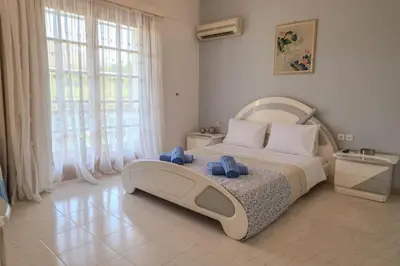 a bedroom with a large bed with blue towels on it at Makiaris Villa in Archangelos