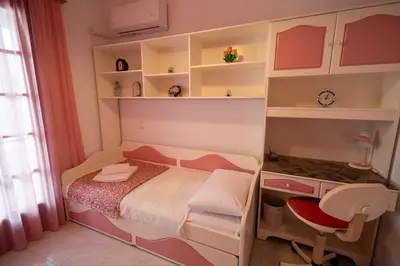 a small bedroom with a bed and shelves at Makiaris Villa in Archangelos