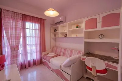 a room with a couch and a desk and a window at Makiaris Villa in Archangelos