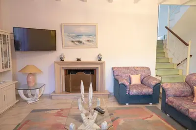 a living room with a fireplace and a tv at Makiaris Villa in Archangelos