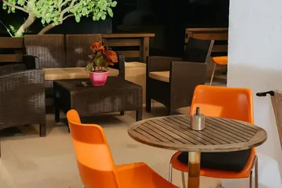 a cafe with a table and chairs and a table and chairs at Sinani Villa - Garden Oasis with Private Pool in Kolimbia