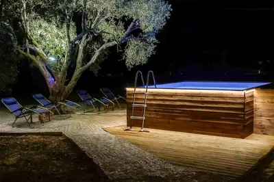 a swimming pool with chairs and a ladder next to it at Sinani Villa - Garden Oasis with Private Pool in Kolimbia