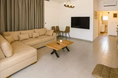 a living room with a couch and a table at Sinani Villa - Garden Oasis with Private Pool in Kolimbia