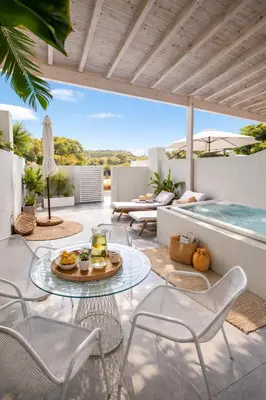 a patio with a table and chairs and a swimming pool at Marev Nature & Luxury Suites -Private Jacuzzi in Ialyssos