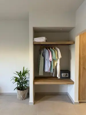 a closet with a shelf with clothes and a plant at Marev Nature & Luxury Suites -Private Jacuzzi in Ialyssos